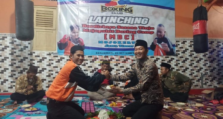 Manager Sasana Tinju MBC Mojokerto Kartono memberikan potongan tumpeng Kepada Kades Banjarsari Subagio sebagai Tanda Tasyakuran Launching