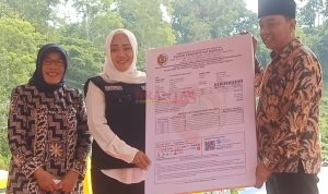 Bupati Mojokerto dr Ikfina Fahmawati didampingi kepala Bapenda Kabupaten Mojokerto Hj Mardiasih SH menyerahkan secara simbolis SPPT PBB - P2 Kepada Kades Sugeng Trawas