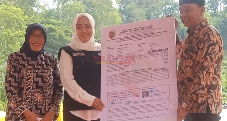 Bupati Mojokerto dr Ikfina Fahmawati didampingi kepala Bapenda Kabupaten Mojokerto Hj Mardiasih SH menyerahkan secara simbolis SPPT PBB - P2 Kepada Kades Sugeng Trawas