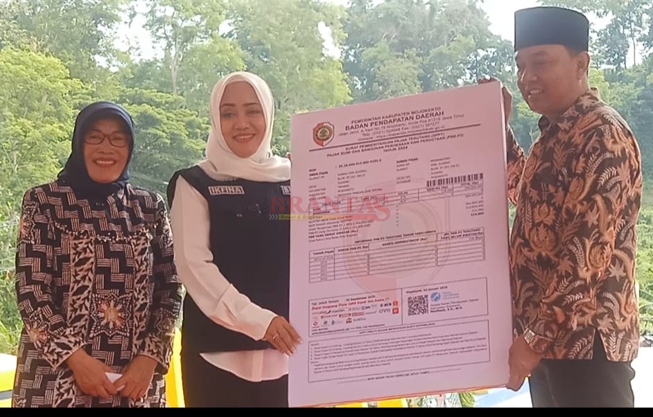 Bupati Mojokerto dr Ikfina Fahmawati didampingi kepala Bapenda Kabupaten Mojokerto Hj Mardiasih SH menyerahkan secara simbolis SPPT PBB - P2 Kepada Kades Sugeng Trawas