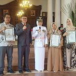 Bupati Mojokerto dr Ikfina Fatmawati didampingi Kepala Disperindag Kabupaten Mojokerto H.M. Iwan Abdillah SH, S.Sos, M.Si, photo bersama Penerima Sertifikat Halal dan Merk Usaha