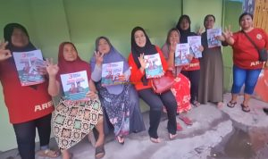 Pembina Relawan Muda Mudi Setia Hj. Setia Puji Lestari SE, MM Photo Bersama Dengan warga sambil memegang Brosur pasangan Bu Risma -Gus Hans Nomor Urut 3