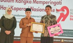 Bupati Mojokerto Gus Barra Didampingi Ketua DPRD Kabupaten Mojokerto H. Ayni Zuroh memberikan Penghargaan Kepada Kuswo Ketua KDMP Desa Cinandang Dawarblandong