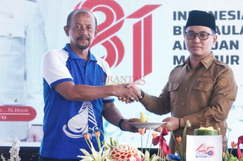 Bupati Gus Barra menyerahkan Tumpeng nasi Kuning kepada Direktur PERUMDAM Mojopahit Mojokerto Fayakun Hidayat SH di HUT ke - 45 PERUMDAM Mojopahit